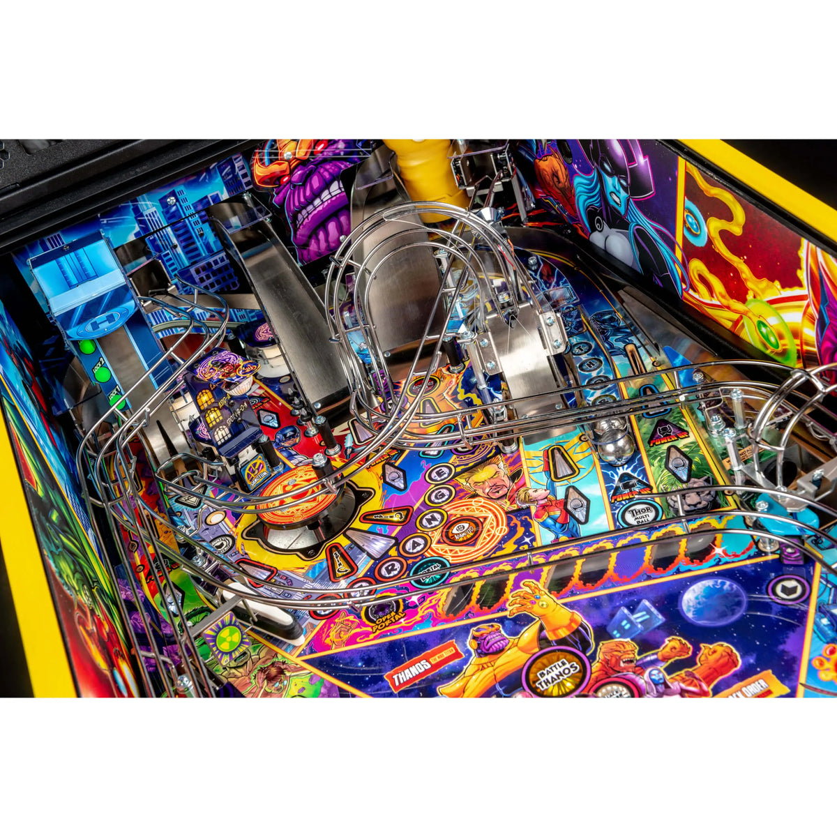 Close-up of a colorful pinball machine playfield with metallic rails, neon graphics, and space-themed artwork including planets, stars, and futuristic city elements.